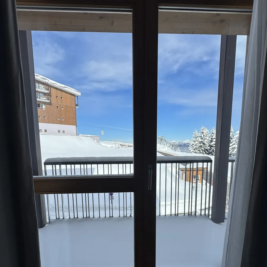Varanda de um quarto aberta para a estação de ski coberta de neve