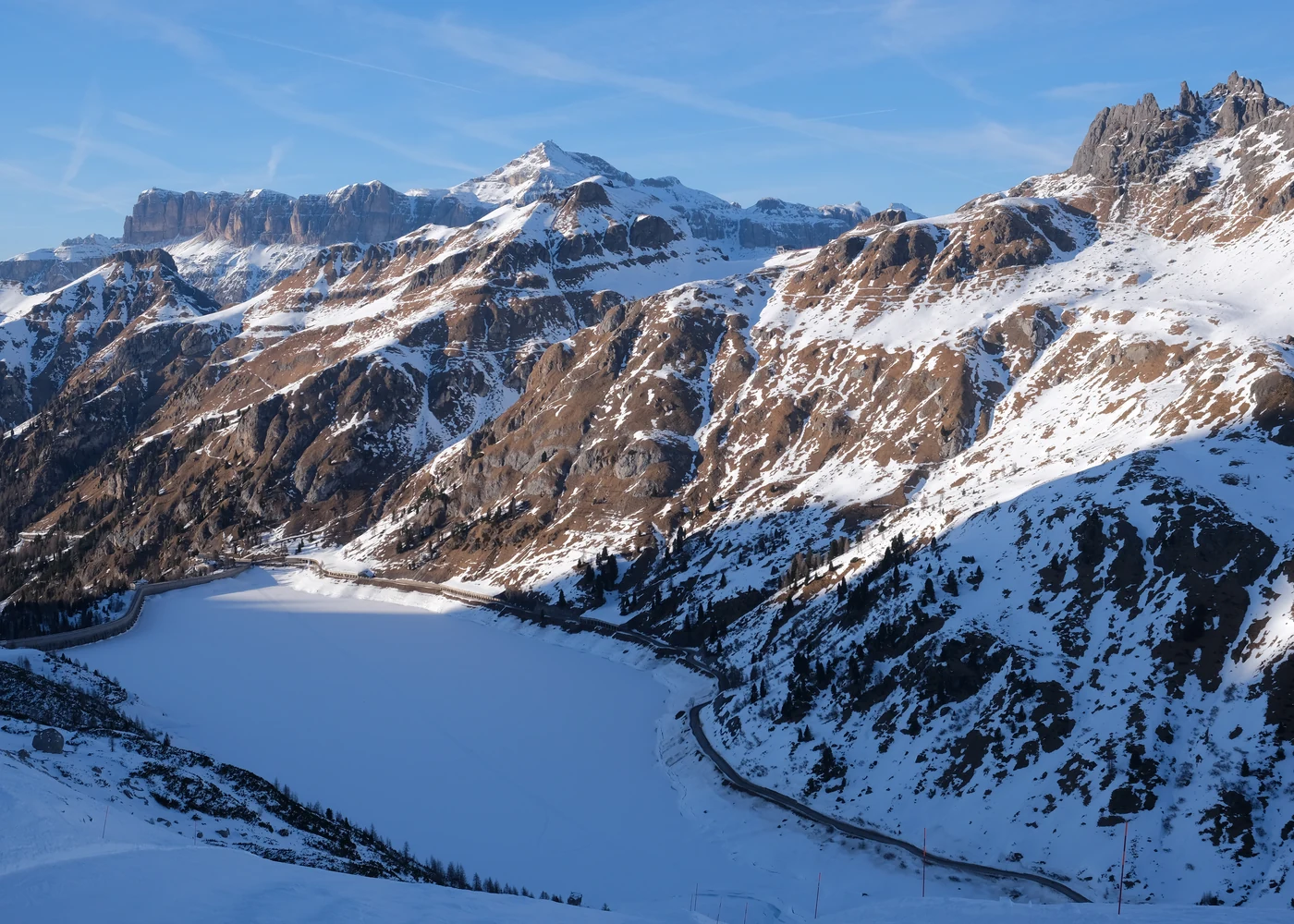 Picos das Dolomitas nevados sobre um lago gelado, na região da Marmolada