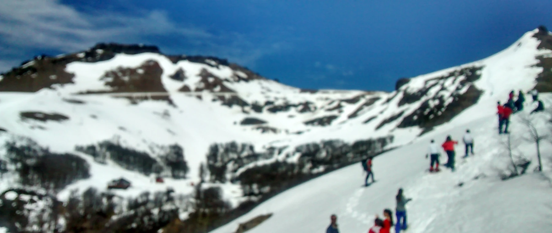 Esquiadores subindo a encosta nevada do Cerro Chapelco